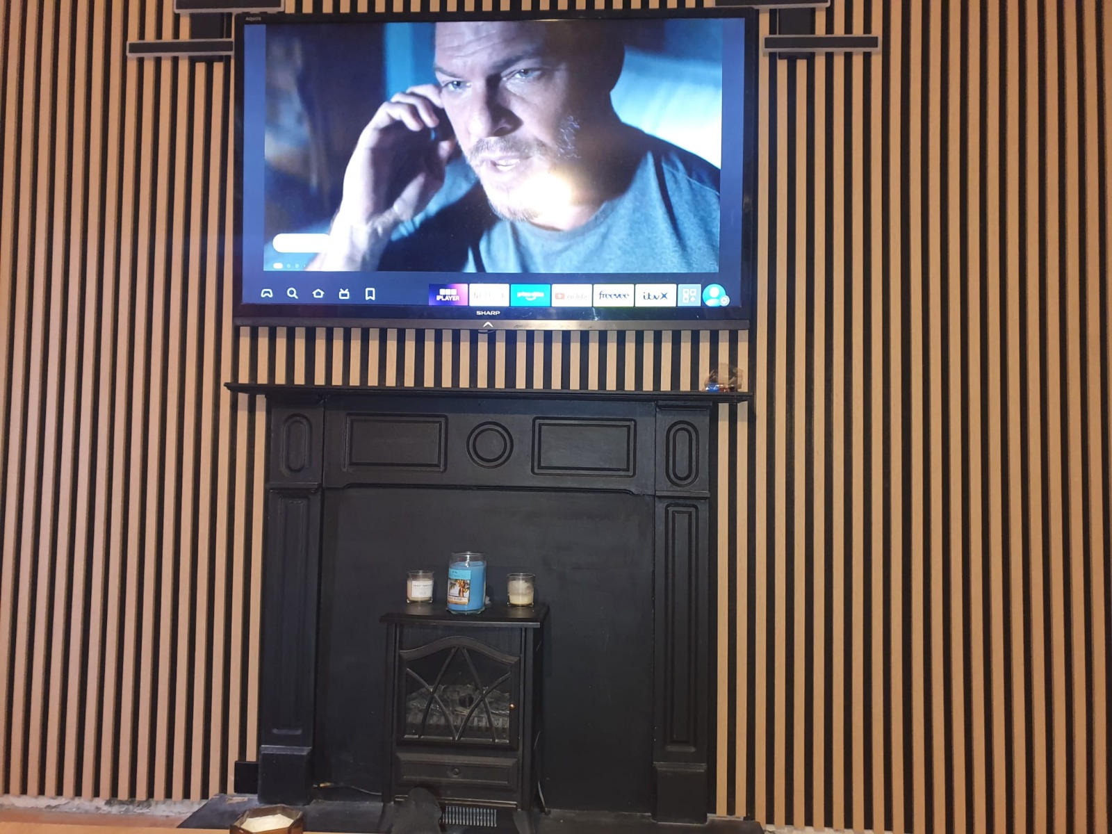 TV mounted on bespoke slatted oak feature wall above fireplace — Cwmbran