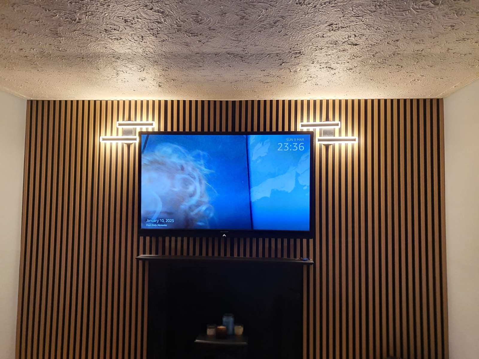 Twin TVs mounted on slatted feature wall — South Wales install