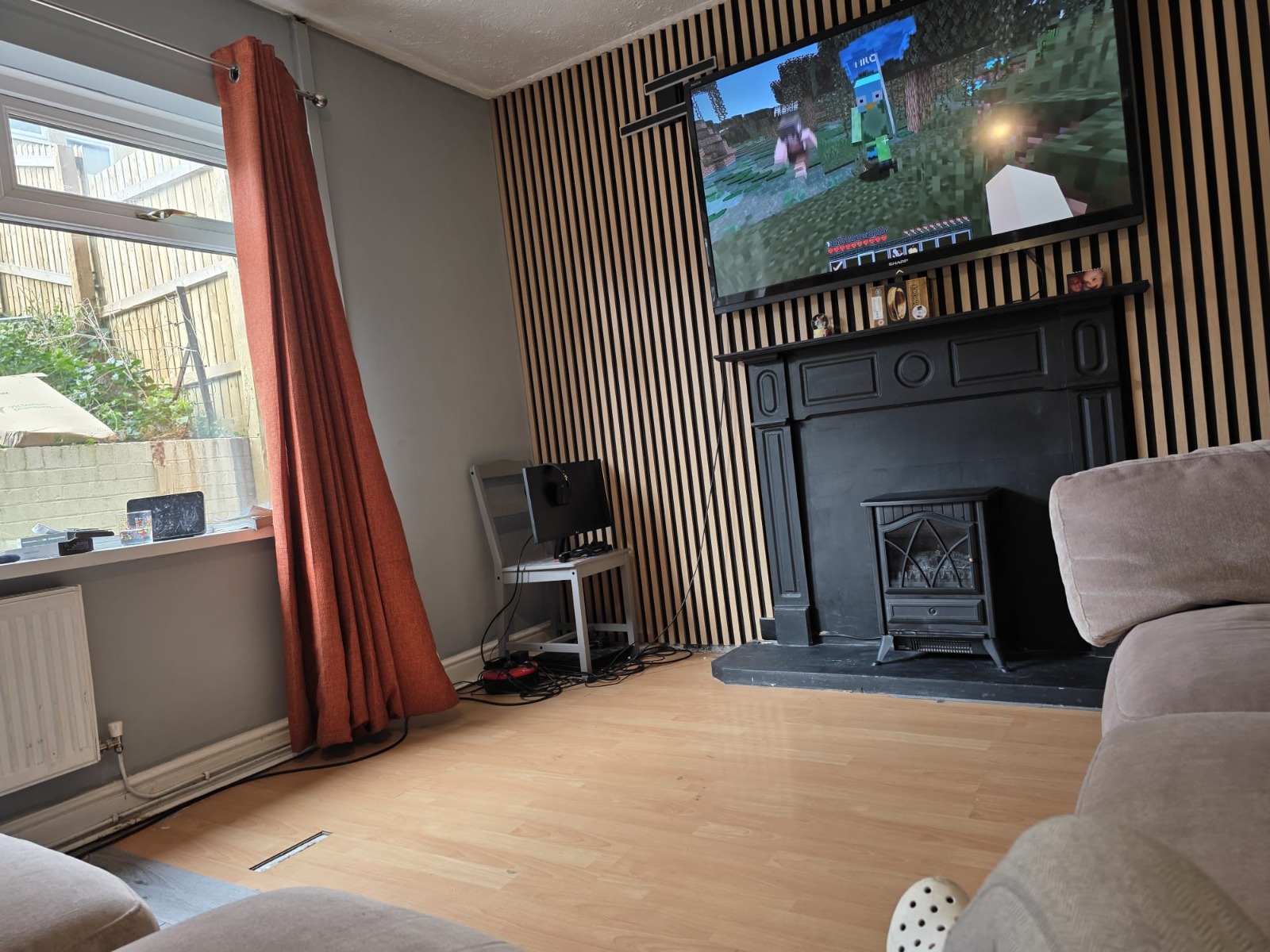 Finished living room with slatted feature wall, TV and log-burner — Cwmbran